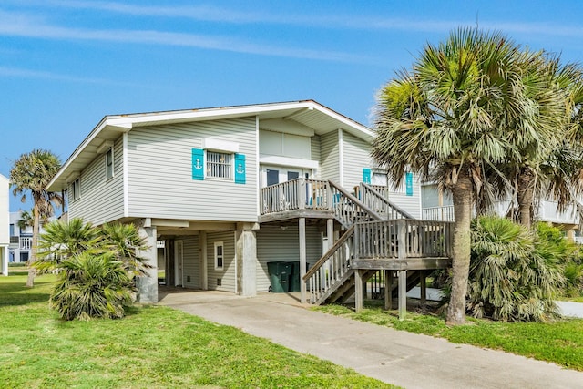 view of front of house featuring stairs, a carport, a front yard, and driveway