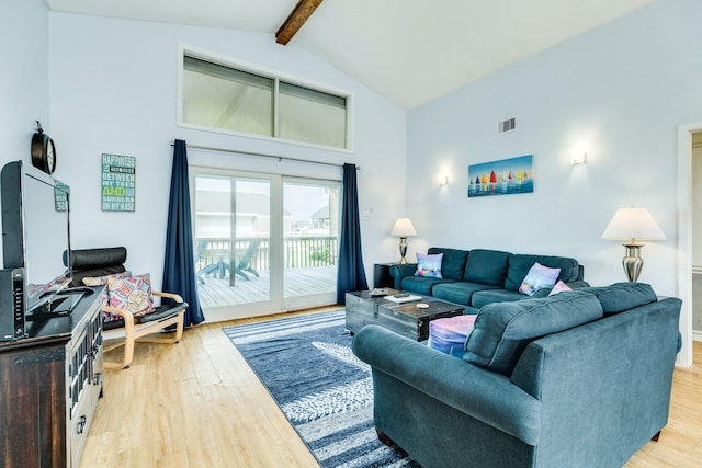 living area with high vaulted ceiling, light wood-style floors, visible vents, and beamed ceiling