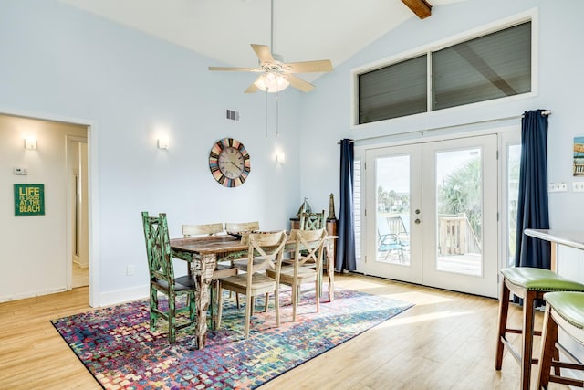 dining room featuring light wood finished floors, visible vents, baseboards, french doors, and high vaulted ceiling