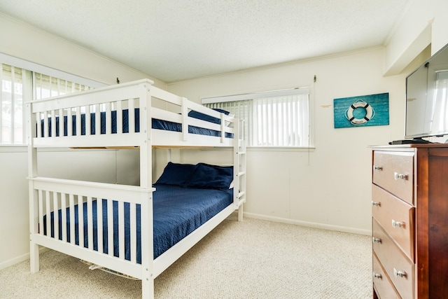 bedroom featuring crown molding, a textured ceiling, carpet, and baseboards