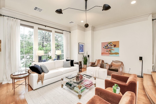 living area with ornamental molding, recessed lighting, visible vents, and light wood finished floors