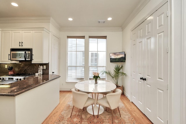 dining room with light wood-style floors, recessed lighting, visible vents, and crown molding