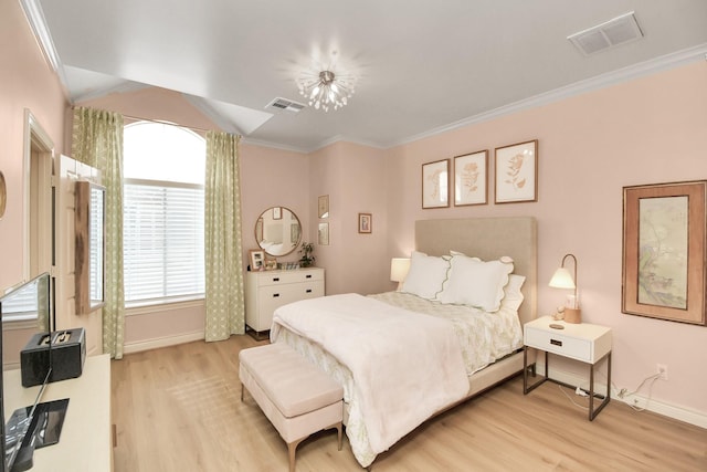 bedroom featuring baseboards, light wood-style flooring, visible vents, and crown molding