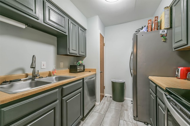 kitchen featuring stainless steel appliances, light countertops, and a sink