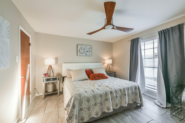 bedroom with a ceiling fan and baseboards