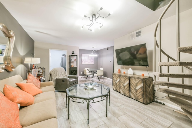 living area featuring visible vents, stairway, and baseboards