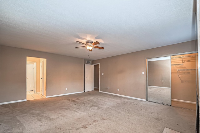 unfurnished bedroom featuring carpet, visible vents, a textured ceiling, and baseboards