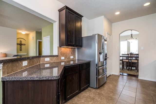 kitchen with tile patterned flooring, backsplash, dark brown cabinets, recessed lighting, and stainless steel fridge