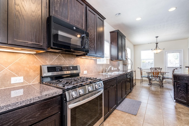 kitchen with dark brown cabinets, gas stove, black microwave, and a sink