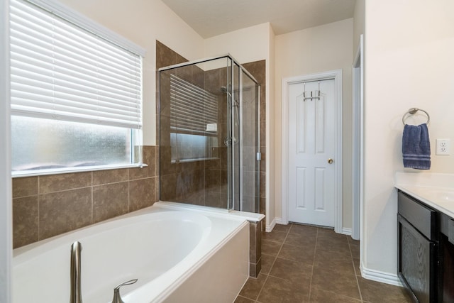 bathroom with vanity, a shower stall, a garden tub, and tile patterned floors