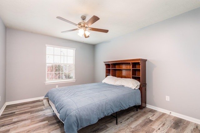 bedroom with a ceiling fan, baseboards, and wood finished floors