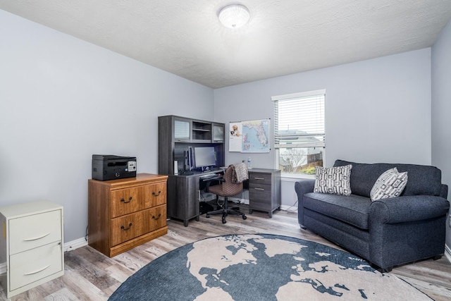 office with baseboards, a textured ceiling, and light wood-style flooring