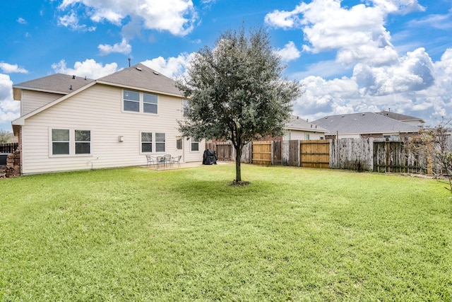 back of property with a patio area, a lawn, and a fenced backyard