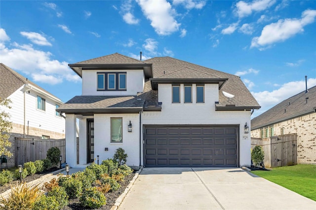 view of front of property with a garage, roof with shingles, fence, and driveway