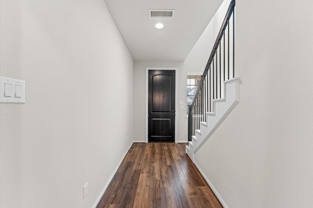 entrance foyer featuring dark wood-style floors, stairway, visible vents, and baseboards