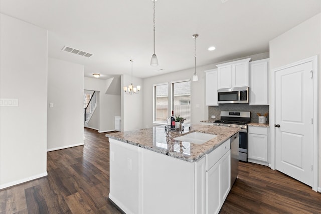 kitchen with stainless steel appliances, dark wood-style flooring, a sink, visible vents, and tasteful backsplash