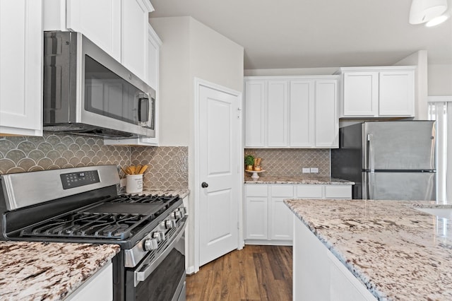 kitchen with appliances with stainless steel finishes, white cabinetry, and dark wood finished floors