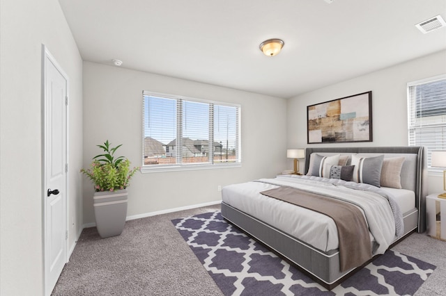 bedroom with carpet floors, visible vents, and baseboards