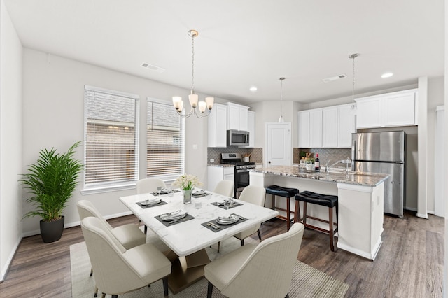 dining room with dark wood-style floors, visible vents, and baseboards