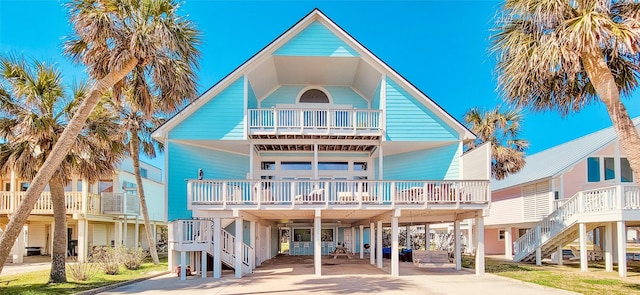 view of front of house featuring a carport, stairway, and concrete driveway