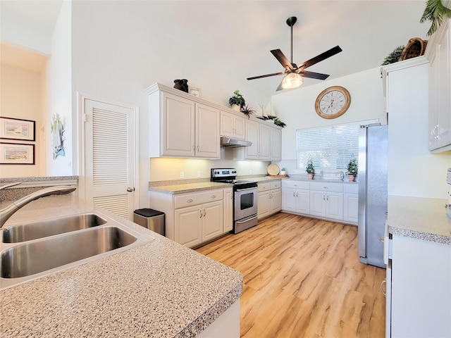 kitchen with ceiling fan, under cabinet range hood, light countertops, a sink, and stainless steel appliances