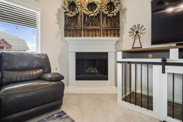 living room featuring a fireplace with raised hearth and tile patterned floors