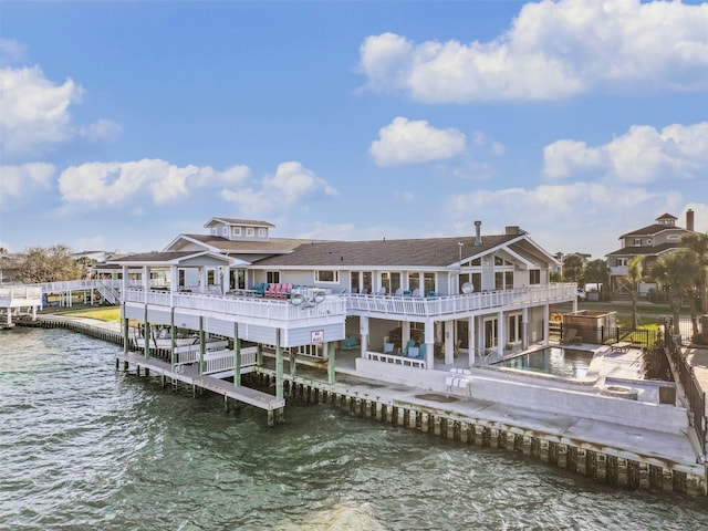 back of property featuring a patio area, a water view, a jacuzzi, and a balcony