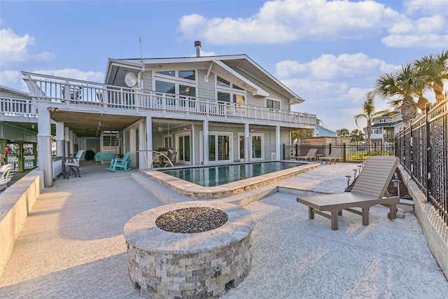 back of house featuring a fenced in pool, an outdoor fire pit, a patio area, and fence