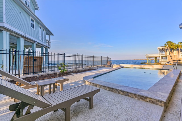 view of pool with a patio, a water view, and fence