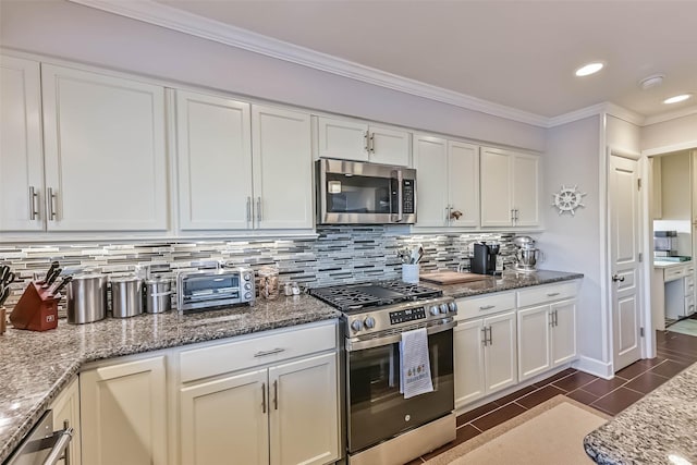 kitchen featuring stainless steel appliances, white cabinetry, crown molding, and backsplash