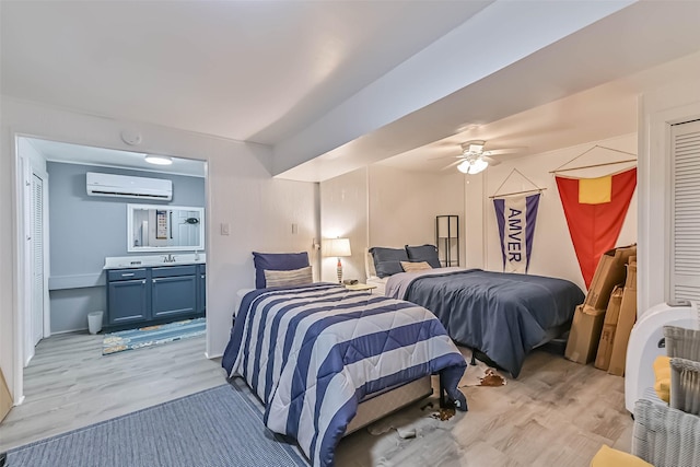 bedroom with a wall unit AC, light wood-type flooring, and a ceiling fan