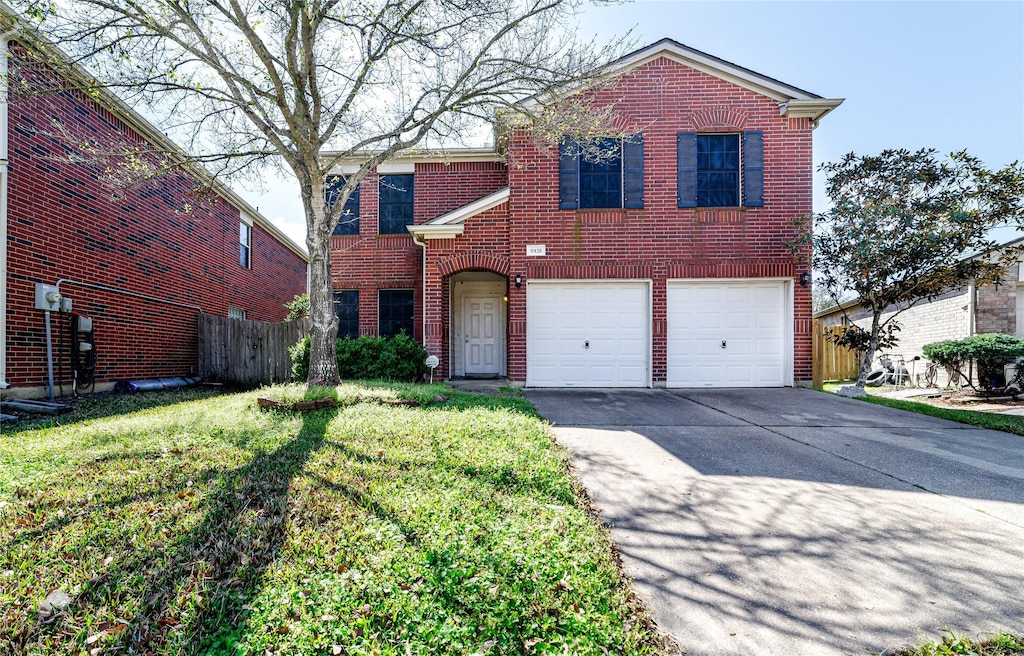 traditional-style house featuring a garage, brick siding, fence, driveway, and a front lawn