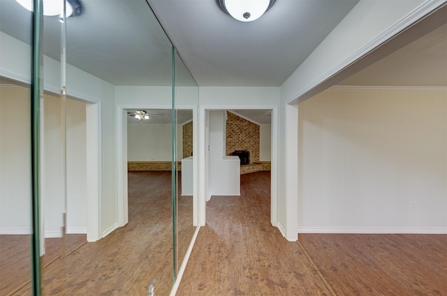 corridor featuring brick wall and wood finished floors