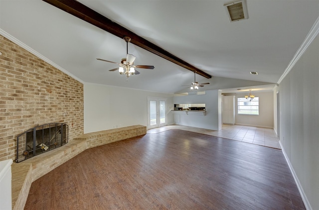 unfurnished living room with visible vents, wood finished floors, vaulted ceiling with beams, crown molding, and a fireplace