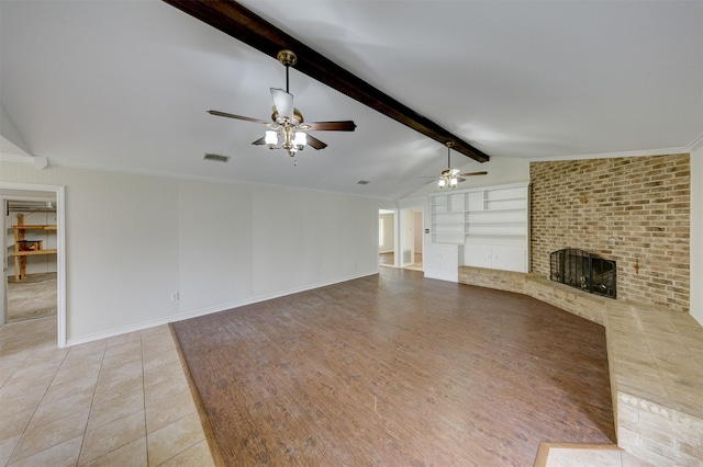 unfurnished living room with lofted ceiling with beams, visible vents, built in features, baseboards, and a brick fireplace