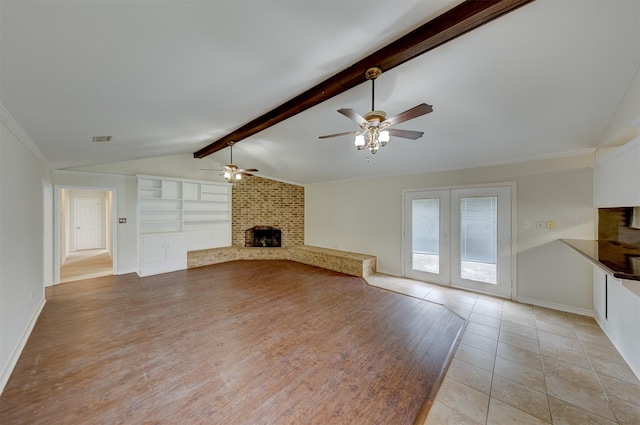 unfurnished living room with vaulted ceiling with beams, light wood-style floors, a fireplace, and baseboards