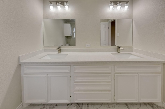 bathroom featuring double vanity, marble finish floor, and a sink