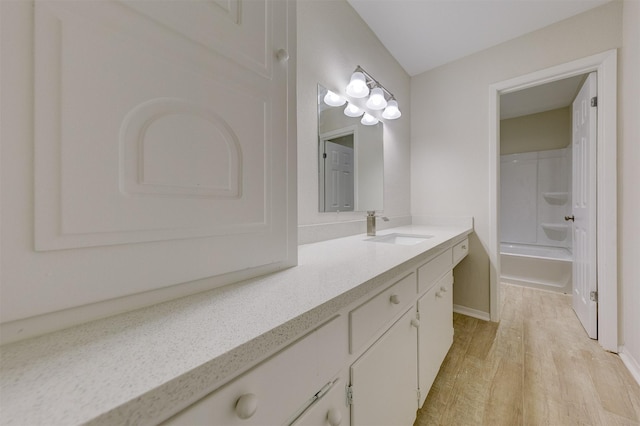 full bath featuring bathtub / shower combination, wood finished floors, and vanity