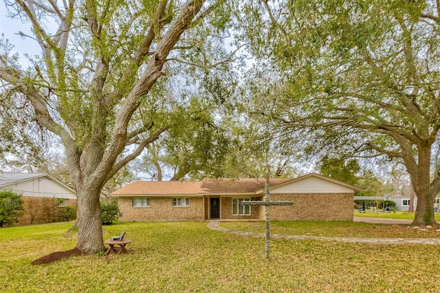 ranch-style house featuring brick siding and a front yard