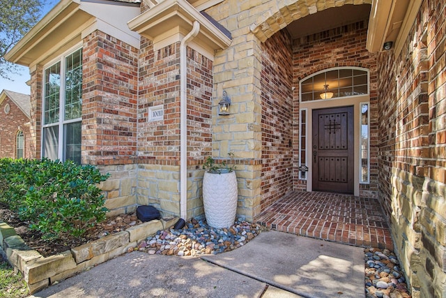 view of exterior entry featuring brick siding