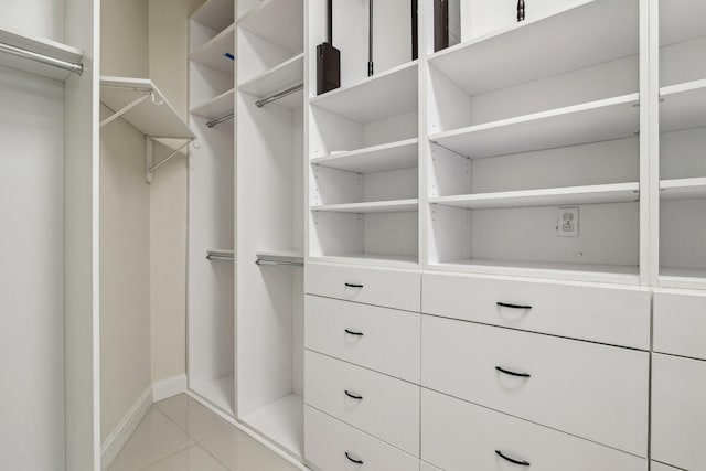 walk in closet with light tile patterned floors