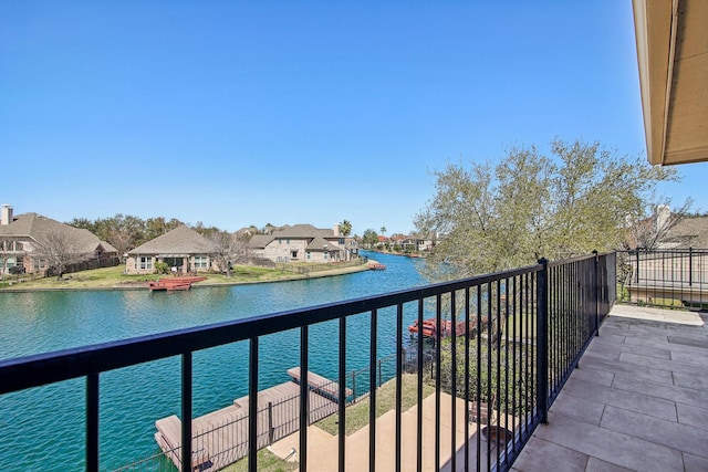 balcony with a residential view and a water view