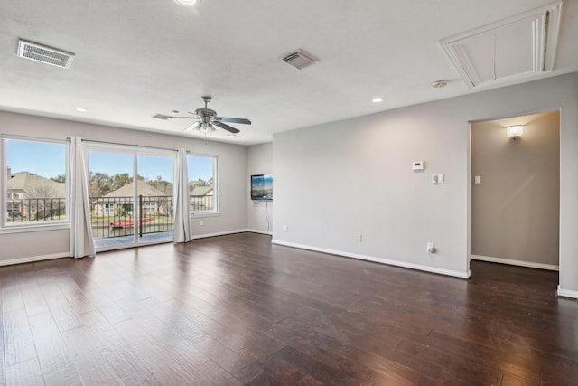 interior space featuring dark wood finished floors, visible vents, attic access, and a ceiling fan