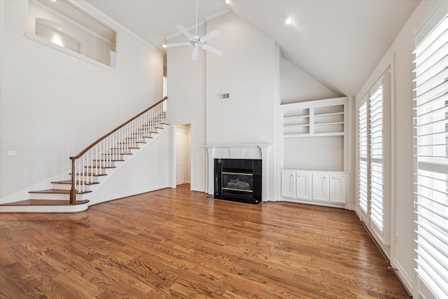 unfurnished living room with a fireplace, wood finished floors, and a healthy amount of sunlight