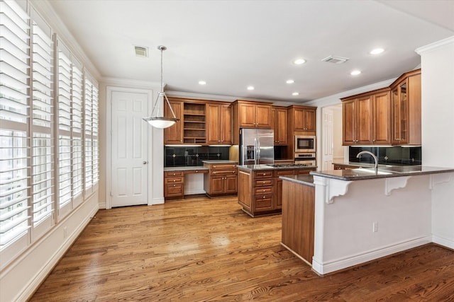 kitchen featuring stainless steel appliances, brown cabinetry, open shelves, and visible vents