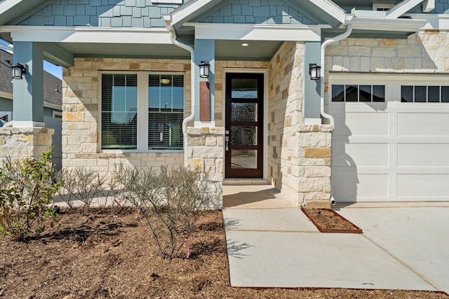 entrance to property with a garage and stone siding