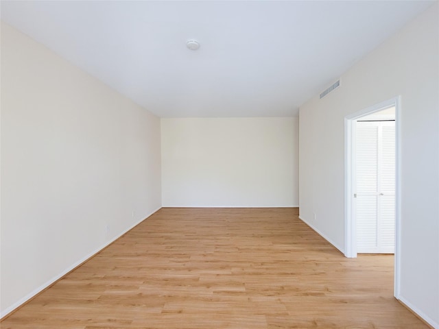 unfurnished room with light wood-type flooring and visible vents