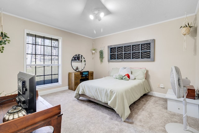 carpeted bedroom with ornamental molding and baseboards