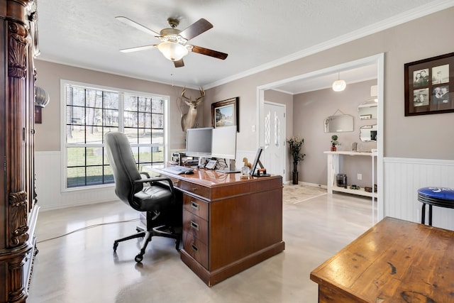 office space featuring a wainscoted wall, crown molding, concrete floors, and a ceiling fan