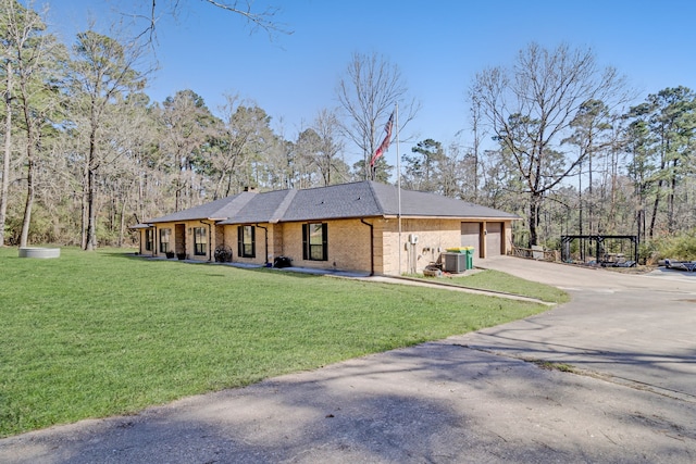 view of front of house featuring central AC unit, an attached garage, brick siding, concrete driveway, and a front lawn